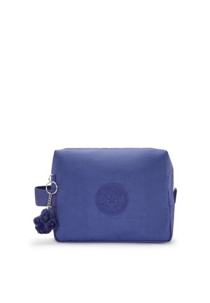 Borsa in nylon viola di forma rettangolare, con logo impresso e una maniglia laterale. Presenta una superficie texture e un ciondolo in pelliccia a pom-pom.