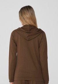 Sudadera marrón de manga larga con capucha redondeada, que presenta una textura suave y puños ajustados, vista desde la parte trasera.