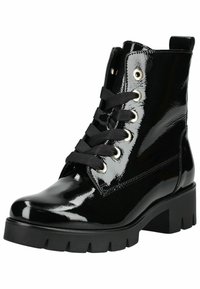 Bottine en cuir verni noir avec bout rond, semelle plate à crampons, six œillets et lacets noirs. Fini brillant unique et talon légèrement surélevé.