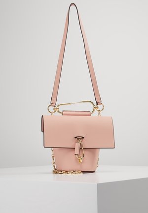 Bolso de mano de cuero rosa con cierre de solapa, cadena y herrajes en tono dorado, y una correa de hombro larga ajustable, mostrado sobre una superficie blanca.