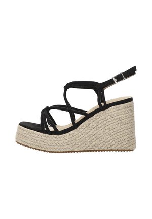 Sandalias de cuña de ante negro con suela de yute trenzada. Presenta tiras entrelazadas y un hebilla ajustable en el tobillo. Diseño de plataforma elevada.
