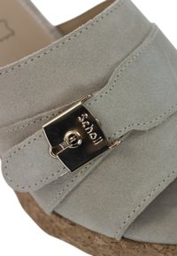 Sandal wedge in suede grigio chiaro con suola in sughero e chiusura metallica con marchio inciso; texture liscia con elementi di design a strati.