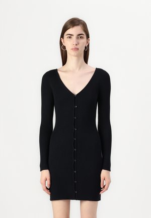 Black ribbed dress featuring a V-neck, long sleeves, and a front button closure. The fabric has a textured look and body-hugging design.
