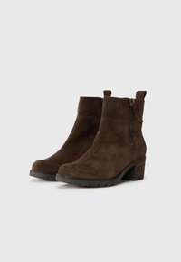 Botas de tobillo de ante marrón con punta redonda, cremallera lateral y tacón de bloque, con una superficie texturizada y una lengüeta en la parte posterior.
