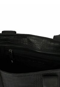 Zwarte handtas met krokodillenstructuur geopend om de zwarte stoffen interior en een ritszak met metalen ritssluiting te onthullen.