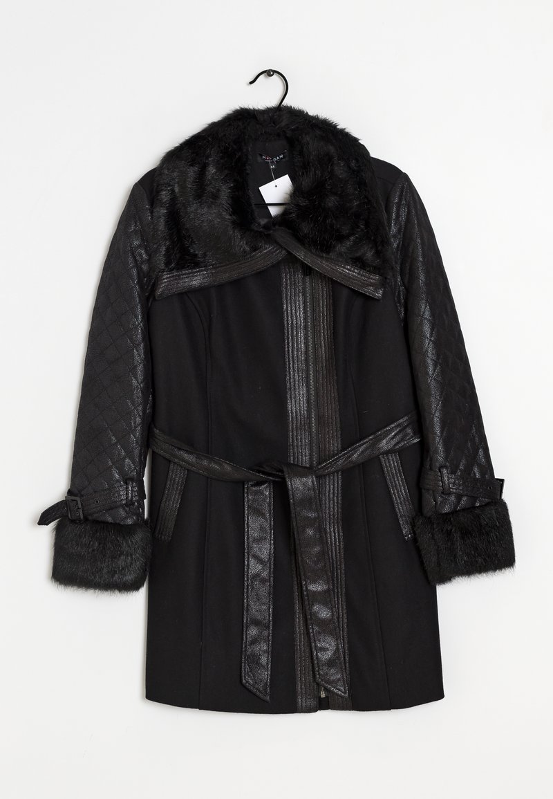 Abrigo de invierno negro con mangas de cuero acolchado, cuello y puños de piel, cintura ceñida con cinturón y cierre frontal con cremallera colgado de una percha negra.
