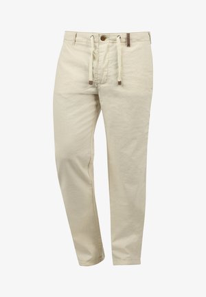 Pantaloni de bumbac bej cu un sistem de închidere cu șnur, având un buton frontal, buzunare laterale și o ușoară strâmtare spre glezne.