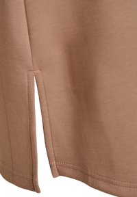 Brun bomuldsstof t-shirt med en sideslidsdetalje og ren syning, der har en glat tekstur og afslappet pasform for nem bevægelse.