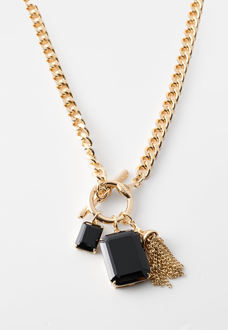 Złoty naszyjnik łańcuszkowy z dwoma prostokątnymi czarnymi kamieniami i frędzlem z łańcuszka, z okrągłym zapięciem typu toggle łączącym elementy.