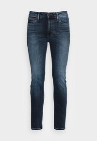 Jeans de mezclilla azul oscuro con corte slim, que cuentan con cinco bolsillos, una sutil textura desvaída y costuras distintivas en el bolsillo trasero.