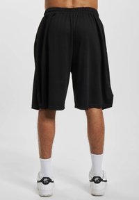 Sorte sportshorts lavet af letvægtsstof, med elastisk talje og løs pasform, der slutter lige over knæet.