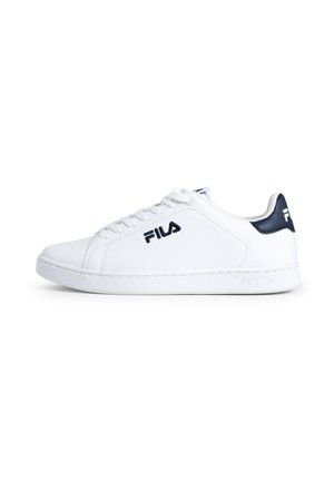 Baskets en cuir blanc avec bout rond, lacets plats et accent bleu marine au niveau du talon. Présente le logo Fila sur le côté et une semelle en caoutchouc texturée.