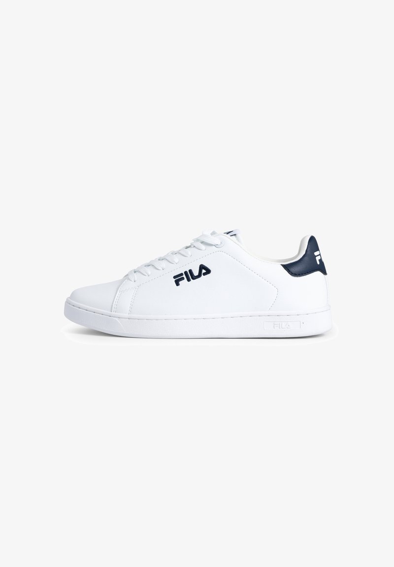 Zapatilla de cuero blanco con punta redonda, cordones planos y acento azul marino en el talón. Presenta el logo de Fila en el lateral y una suela de goma texturizada.