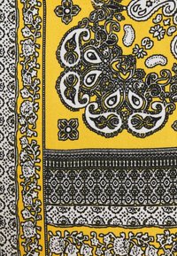 Écharpe en tissu jaune avec des motifs paisley et floraux noirs et blancs complexes. Les bords présentent des designs géométriques détaillés. Texture douce.