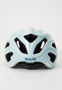Vaaleansininen pyöräilykypärä, jossa on ilmanvaihtoaukkoja ja musta hihna, esittäen "KASK"-logoa selvästi etupuolella.