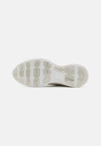 Sole di scarpa sportiva in gomma bianca e grigia chiara con motivi testurizzati, scanalature e sezioni di grip variabile. Design pulito e minimalista.