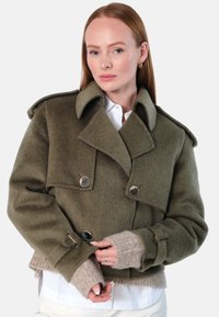 Olivengrønn ullblanding cropped jakke med bred krage, dobbel brystknapplukking og ribbestrikkede beige ermer.