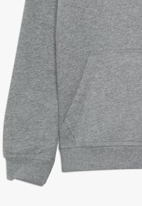 Sweatshirt gris avec une poche kangourou, des poignets et un ourlet côtelés, fabriqué en un mélange de coton doux avec une texture lisse.