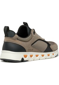 Scarpe da ginnastica da uomo con una combinazione di colori grigio e nero, materiali in suede e mesh, colletto imbottito e suola bianca con dettagli arancioni.