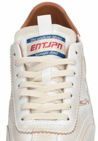 Baskets en cuir blanc avec lacets crème, intérieur marron, et étiquette sur la languette portant l'inscription "The archive series ENTJPN Vintage Soul."