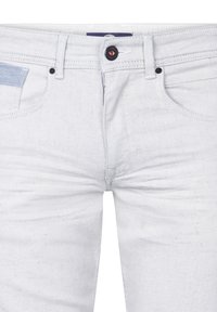Lichtblauwe denim jeans met een gladde textuur, vijf zakken en een knoopsluiting met een contrasterende rode accent.