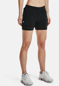 Czarne szorty sportowe z dopasowaną podszewką, elastyczną talią i detalem z logo. W zestawie z białymi sneakerami z kolorową wzorzystą podeszwą.