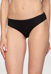 Bikini in cotone nero con taglio a vita bassa, texture liscia e senza decorazioni visibili. Design semplice e minimalista.