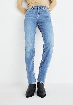 High-rise blue jeans with a tapered fit, featuring a classic five-pocket design and subtle fading, paired with black ankle boots.