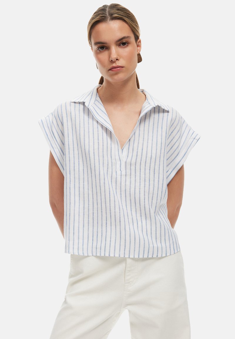 Camiseta blanca de manga corta con rayas verticales en azul claro, que presenta un cuello y escote en V. Hecha de un tejido ligero y texturizado.