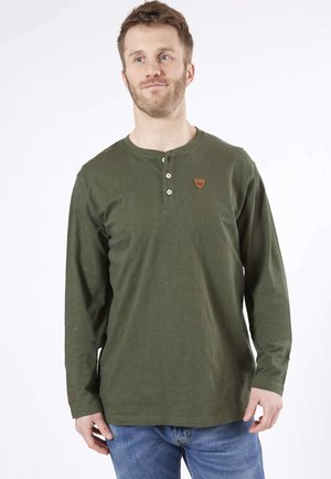 Chemise henley à manches longues, couleur olive, fabriquée en matériau doux. Comprend un col rond, une patte de boutonnage et un petit badge logo sur la poitrine.