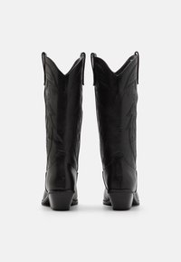 Czarne skórzane buty kowbojskie z wysmuklonymi noskami, dekoracyjnym haftem po bokach i niskim, blokowym obcasem. Gładka faktura i elegancki design.