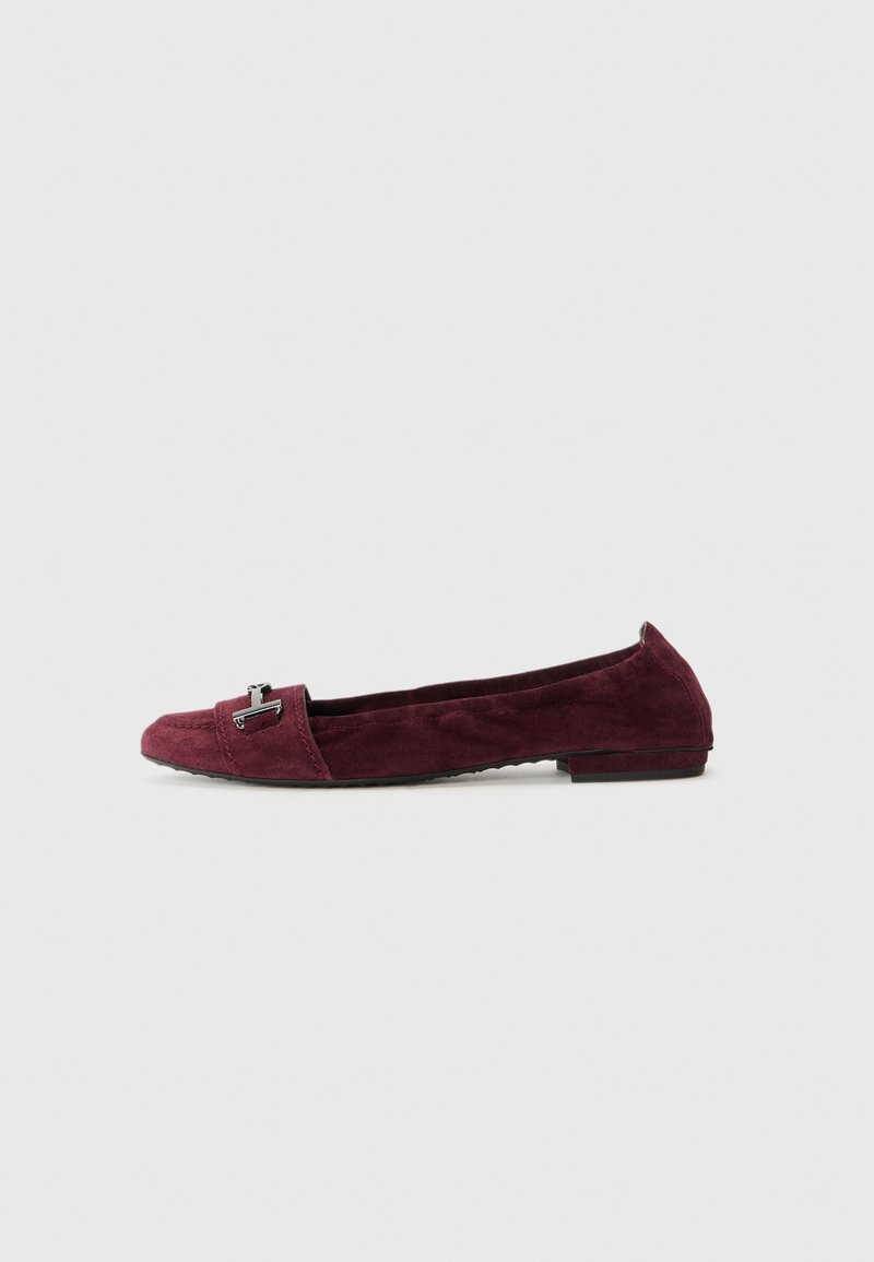 Pantofole in suede bordeaux con tacco basso, dotate di un piccolo accento metallico sulla punta e dettagli cuciti lungo la cucitura superiore.