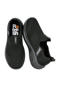 Zapatos negros tipo slip-on con parte superior de malla transpirable, superficie texturizada, suela flexible y marcado en contraste en la plantilla y el lateral.