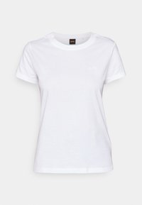 T-shirt blanc à manches courtes avec col rond, petit logo "BOSS" embossé sur le côté gauche de la poitrine et étiquette noire au niveau du col avec texte orange "BOSS".