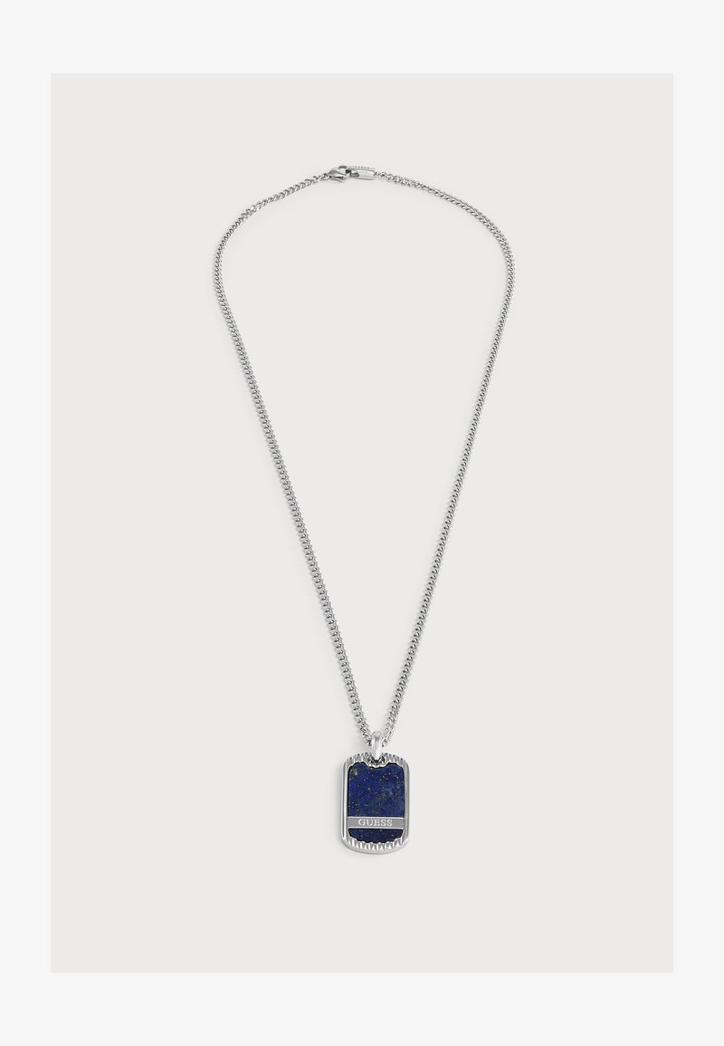 Collier chaîne en argent avec pendentif en pierre bleue rectangulaire arborant le logo "GUESS" sur fond uni.