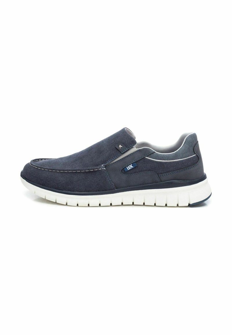 Zapatos de lona azul marino tipo slip-on con una parte superior de tela suave, plantilla acolchada y una suela de goma blanca con un dibujo texturizado para mayor agarre.