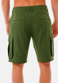 Pantaloni cargo verdi realizzati in cotone misto, con tasche laterali, una vestibilità comoda e una texture pulita e liscia. Dettagli di cuciture rinforzate visibili.