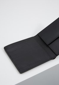 Black leather wallet with multiple card slots and a single compartment. Smooth texture with minimal stitching and branding embossed inside.