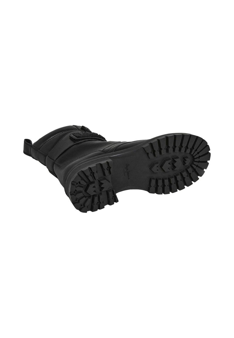 Botín negro de invierno con una suela de goma texturizada, un grueso dibujo para tracción y una parte superior acolchada que incluye una correa de Velcro.