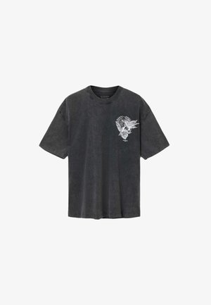 Black, short-sleeve t-shirt made of soft fabric, featuring a detailed white skull graphic with foliage on the front. Round neck, relaxed fit.