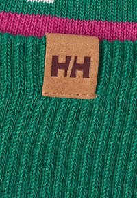 Tejido verde de punto con un patrón texturizado, que presenta una franja rosa y una etiqueta de cuero marrón grabada con "H/H."