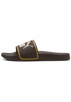 Brązowa klapka Puma z teksturowanym paskiem, białym logo Puma i żółtą lamówką, płaska podeszwa, widok z boku na białym tle.