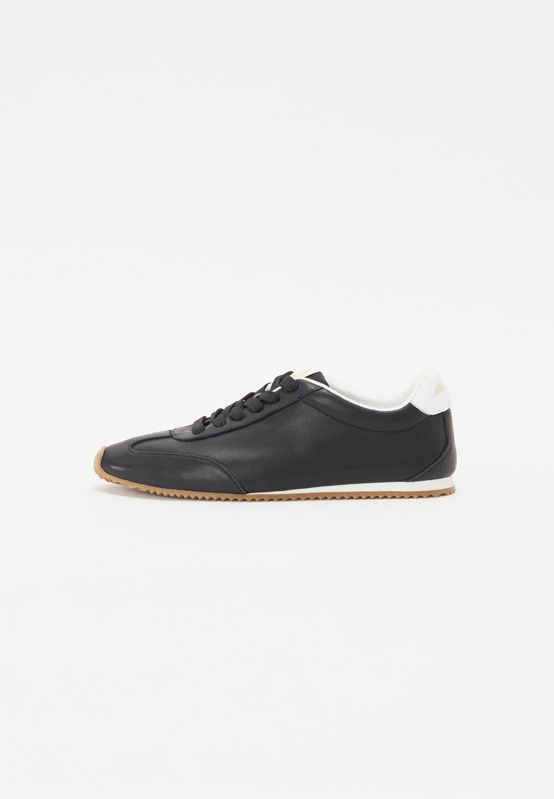 Musthave musta tennis jalaga tekstuuriga nahk, lipsud ees, valge pehme kaelus ning pruun kummist tald, millel on lokkis muster.