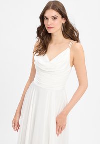 Witte avondjurk met een coupenaaikraag, geplooide taille en vloeiende rok. Heeft dunne bandjes en een gladde, zachte textuur.