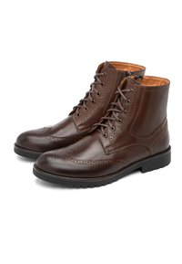 Brązowe skórzane botki z dekoracyjnym przeszyciem typu brogue, okrągłym noskiem i wiązane z przodu. Charakteryzują się gładkim wykończeniem i gumową podeszwą zapewniającą przyczepność.