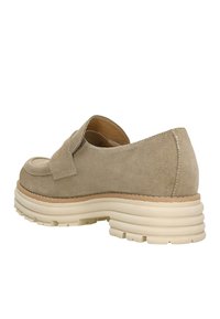 Scarpa in suede beige con un design a bassa apertura e una fascia larga sulla parte anteriore. Suola bianca spessa con una finitura testurizzata e un aspetto stratificato.