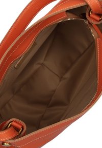 Interno di una borsa a tracolla in pelle arancione con una fodera liscia e beige. Include una tasca con zip e cuciture visibili lungo i bordi.