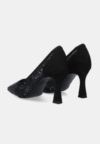 Zapatos de tacón alto negros con un patrón tejido texturizado y acentos de ante. Punta afilada y diseño de tacón curvado.