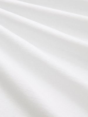 Baumwollstoff, weiße Farbe, glatte Textur mit subtilen Falten und Knicken. Gleichmäßige Oberfläche, leicht reflektierend, ohne Muster oder Akzente.