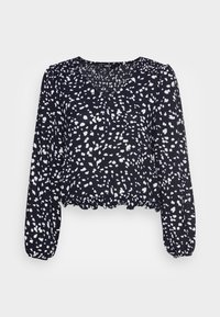 Schwarze Bluse mit einem weißen Punktmuster, langen puffärmel, einem V-Ausschnitt und einem gerafften Saum. Hergestellt aus leichtem Stoff.